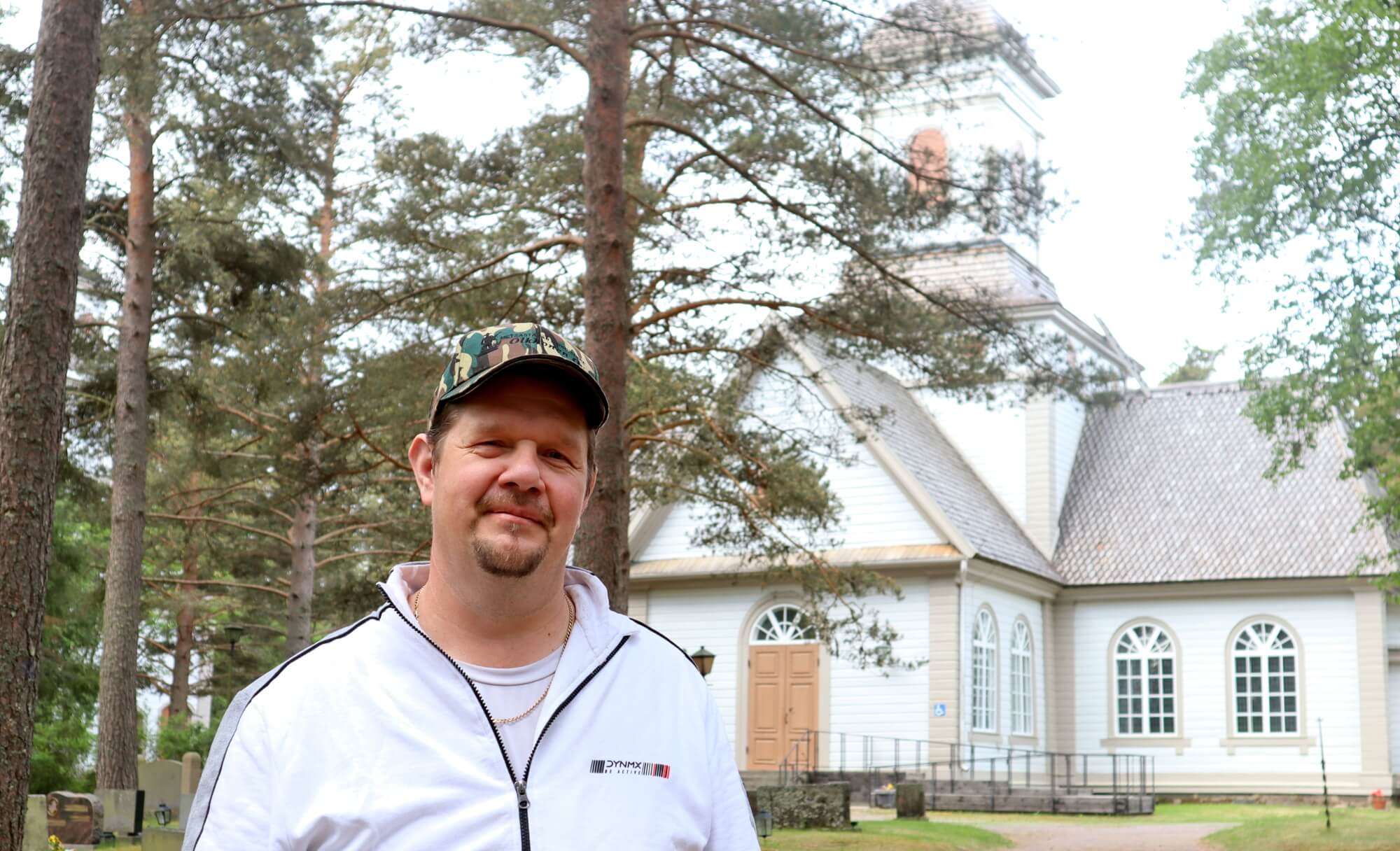 Seurakuntamestari Tuomo Mettovaara taustalla Siikajoen kirkko.